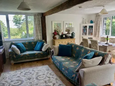 a living room with a couch and a chair at Fuchsia Cottage in Porthallow