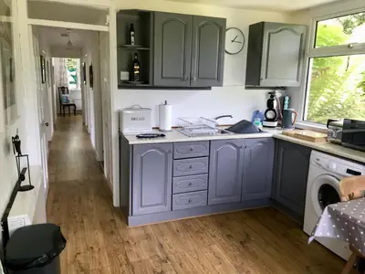 a kitchen with blue cabinets and a sink at Fuchsia Cottage in Porthallow