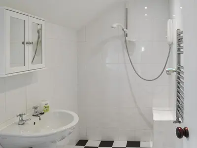 a white bathroom with a sink and a shower at Sunnyside in Delabole