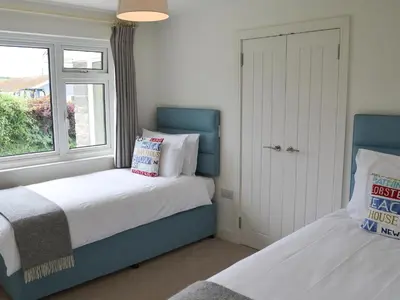 a bedroom with two beds and a window at Moonraker in Port Isaac