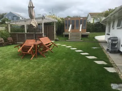 a backyard with two picnic tables and an umbrella at Moonraker in Port Isaac