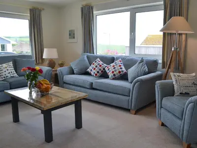 a living room with a blue couch and a coffee table at Moonraker in Port Isaac