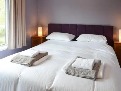 a bedroom with a bed with two towels on it at Heatherstone in Illogan