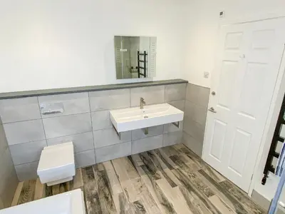 a bathroom with a sink and a toilet and a mirror at Heatherstone in Illogan