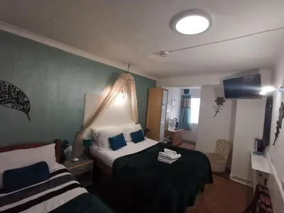 a hotel room with two beds and a bathroom at Aquarius B&B in Newquay