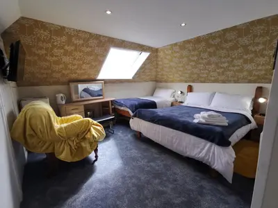 a bedroom with two beds and a window at Aquarius B&B in Newquay