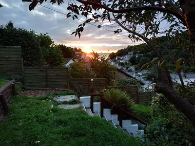 a garden with a sunset in the background at dog friendly nancecliff cottages in Looe
