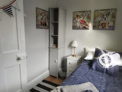 a bedroom with a bed with a blue comforter at dog friendly nancecliff cottages in Looe