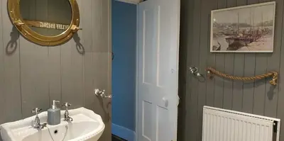 a bathroom with a sink and a mirror at dog friendly nancecliff cottages in Looe