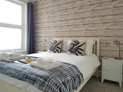 a bedroom with a bed and a wooden wall at Saltwater in St Ives