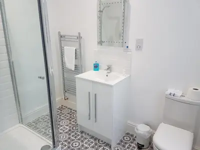 a white bathroom with a shower and a sink at Saltwater in St Ives