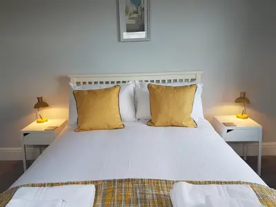 a bedroom with a white bed with two lamps at Saltwater in St Ives