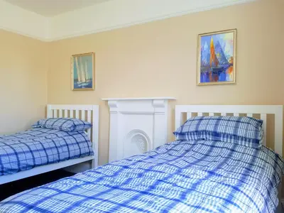 a bedroom with two beds and a fire place at Big, Beautiful, Cosy Falmouth House in Falmouth