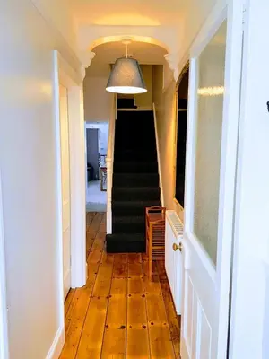 a hallway with a staircase and a stair case at Big, Beautiful, Cosy Falmouth House in Falmouth