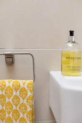 a bottle of soap sitting on top of a toilet at The Old Post Office Apartment in Falmouth