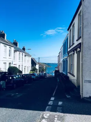 a street with houses and cars parked on the side at The Old Post Office Apartment in Falmouth