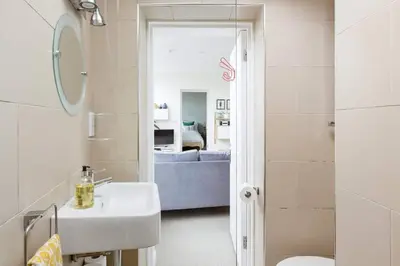 a bathroom with a sink and a mirror at The Old Post Office Apartment in Falmouth