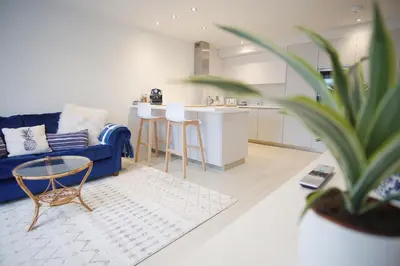 a living room with a blue couch and a table at Saltwater Newquay in Newquay