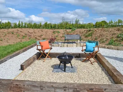 two chairs and a grill in a gravel yard at The Wool Shed in Saint Ewe