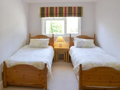 two twin beds in a room with a window at Trelawny Court in Saint Minver
