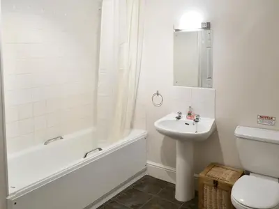 a bathroom with a tub and a sink and a toilet at Trelawny Court in Saint Minver