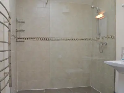 a bathroom with a shower and a sink at Welly's Wallow in Saint Kew