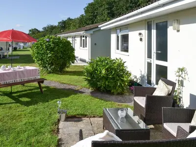 a patio with a table and chairs and a table sidx sidx sidx at Westville By The Stream in Saint Cleer