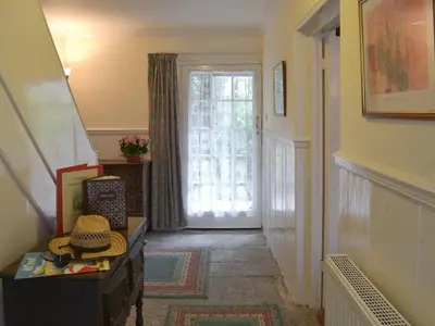 a hallway with a door leading to a room with a window at The Farmhouse in Lostwithiel