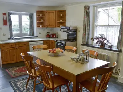 a kitchen with a table with a bowl of fruit on it at The Farmhouse in Lostwithiel