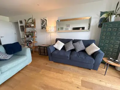 a living room with a blue couch and a mirror at Ocean View Beach Rd in Newquay