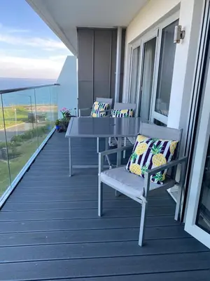 a balcony with two chairs and a table on a balcony at Ocean View Beach Rd in Newquay