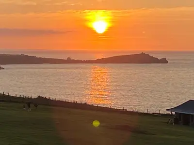 a sunset over a body of water with a beach at Ocean View Beach Rd in Newquay
