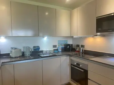 a kitchen with white cabinets and a counter top at Ocean View Beach Rd in Newquay