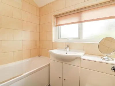 a bathroom with a sink and a bath tub at Bayview in Newquay