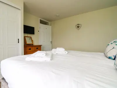 a bedroom with a white bed with towels on it at Bayview in Newquay