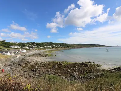 a view of a beach with a boat in the water at Cockle Island Cottage in Porthallow