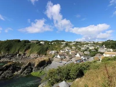 a small town on the shore of a body of water at Cockle Island Cottage in Porthallow