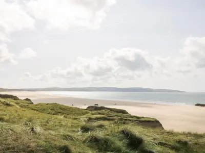 a view of a beach with people in the water at Godrevy Barn in Hayle