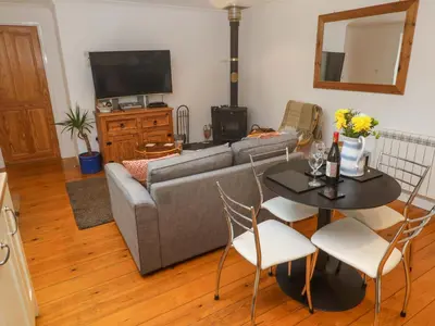 a living room with a couch and a table with chairs at Godrevy Barn in Hayle