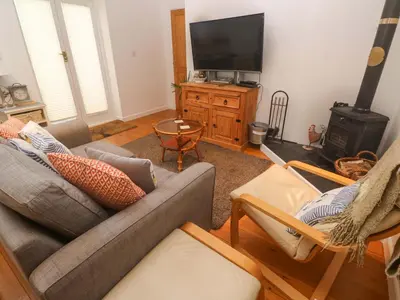 a living room with a couch and a television at Godrevy Barn in Hayle