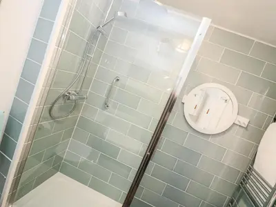 a bathroom with a shower with a toilet in it at Rosa Cottage in Porthleven