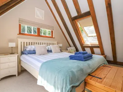 a bedroom with a bed and a wooden table at Oaklands in Camelford