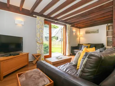 a living room with a leather couch and a television at Oaklands in Camelford
