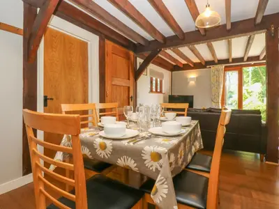 a dining room with a table with chairs and a tableclotholitics at Oaklands in Camelford