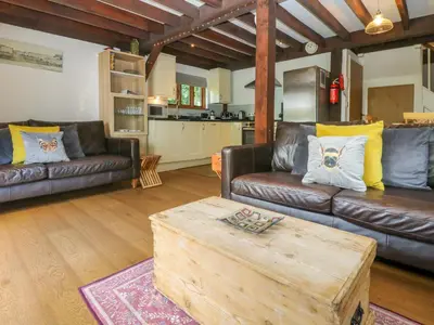 a living room with leather couches and a coffee table at Oaklands in Camelford