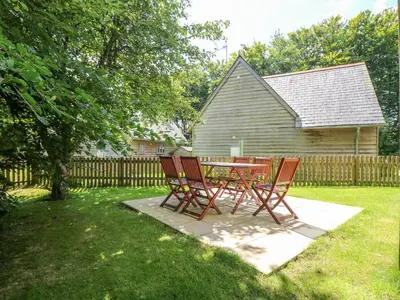 two chairs and a table in a yard with a fence at Oaklands in Camelford