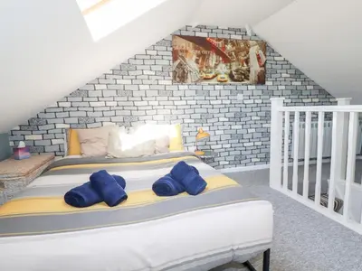 a bedroom with a bed with blue pillows on it at Alma House 2 in Perranporth