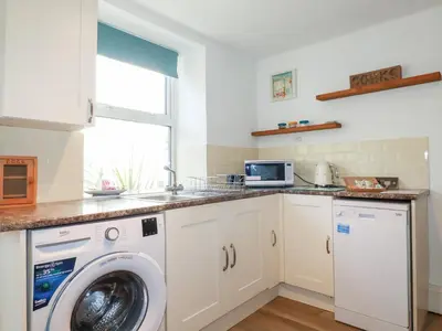 a kitchen with a washing machine and a sink at Alma House 2 in Perranporth
