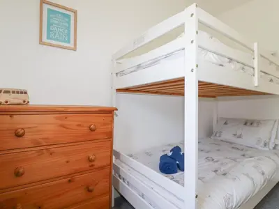 a white bunk bed in a bedroom with a dresser at Alma House 2 in Perranporth