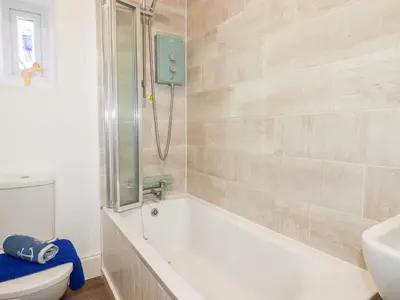 a bathroom with a tub and a toilet and a sink at Alma House 2 in Perranporth